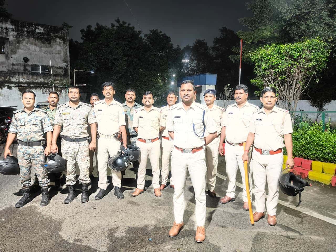 रात के समय बिष्टुपुर इलाके में पुलिसकर्मियों की एक टीम सड़क पर खड़ी दिखाई दे रही है। तस्वीर में करीब 10 पुलिसकर्मी नजर आ रहे हैं। अधिकांश पुलिसकर्मी वर्दी में हैं, जबकि कुछ जवान सुरक्षा उपकरणों के साथ दिखाई दे रहे हैं। सामने खड़े एक पुलिस अधिकारी के हाथ में डंडा है। कुछ पुलिसकर्मियों के हाथ में हेलमेट भी हैं। पृष्ठभूमि में सड़क, पेड़-पौधे, स्ट्रीट लाइट और कुछ इमारतें दिखाई दे रही हैं। पूरी टीम रात में रात्रि गश्ती अभियान के दौरान एक साथ खड़ी होकर तस्वीर खिंचवाती नजर आ रही है।
