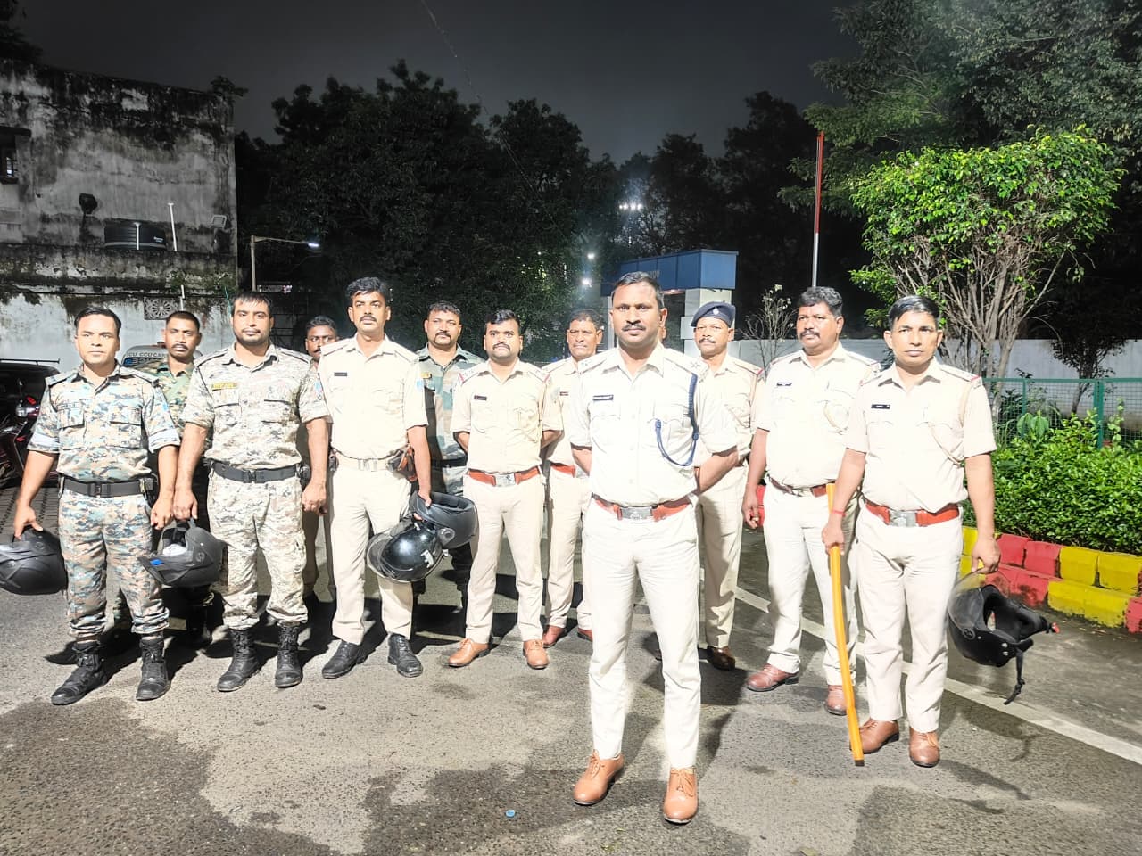 रात के समय बिष्टुपुर इलाके में पुलिसकर्मियों की एक टीम सड़क पर खड़ी दिखाई दे रही है। तस्वीर में करीब 10 पुलिसकर्मी नजर आ रहे हैं। अधिकांश पुलिसकर्मी वर्दी में हैं, जबकि कुछ जवान सुरक्षा उपकरणों के साथ दिखाई दे रहे हैं। सामने खड़े एक पुलिस अधिकारी के हाथ में डंडा है। कुछ पुलिसकर्मियों के हाथ में हेलमेट भी हैं। पृष्ठभूमि में सड़क, पेड़-पौधे, स्ट्रीट लाइट और कुछ इमारतें दिखाई दे रही हैं। पूरी टीम रात में रात्रि गश्ती अभियान के दौरान एक साथ खड़ी होकर तस्वीर खिंचवाती नजर आ रही है।