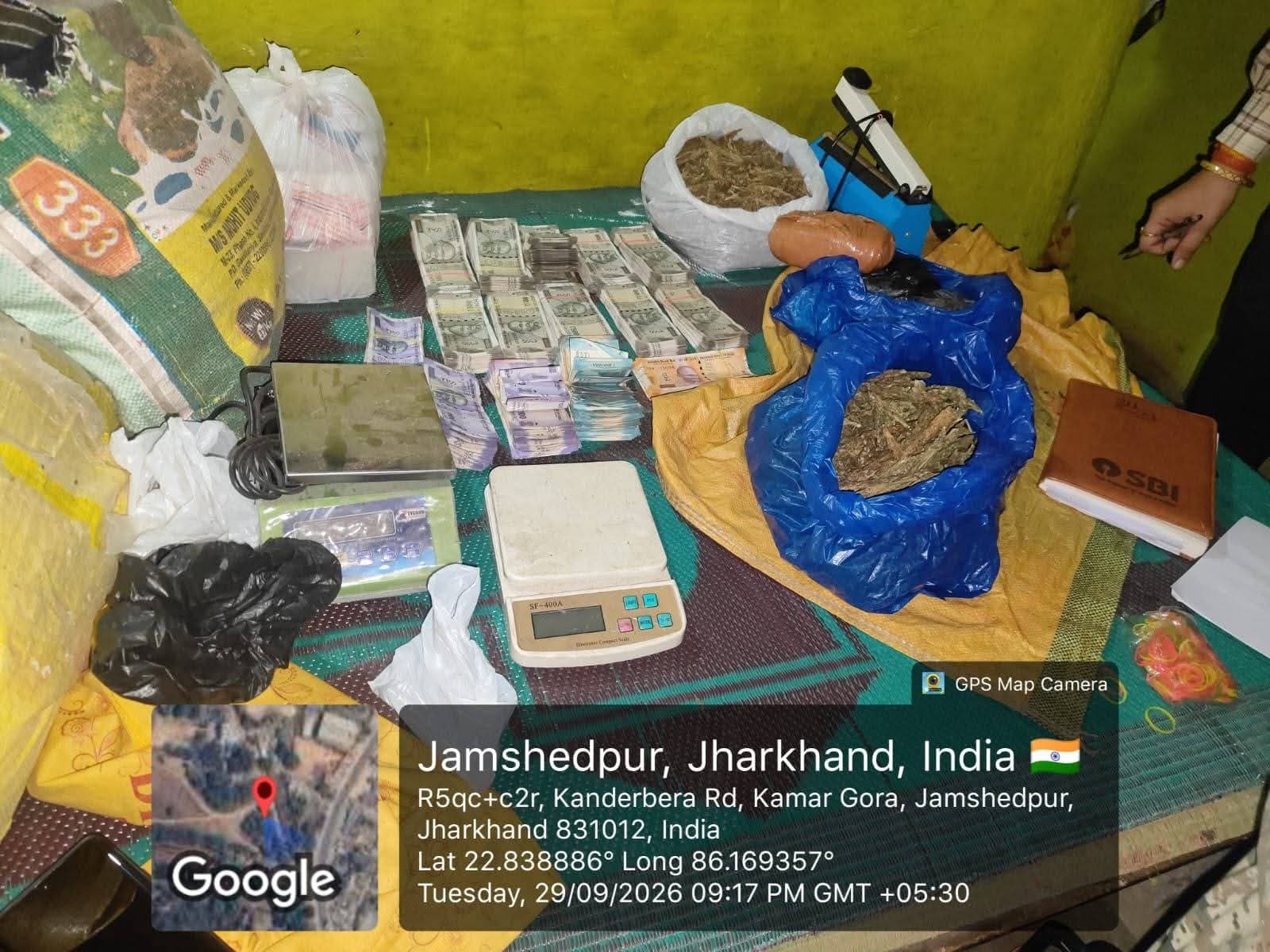 तस्वीर में चारपाई पर अलग-अलग बंडलों में रखी भारतीय मुद्रा, दो weighing scales और पॉलीथिन में रखा सूखा पदार्थ दिखाई दे रहा है। पास में पैकेजिंग के लिए इस्तेमाल होने वाला सामान भी नजर आ रहा है।