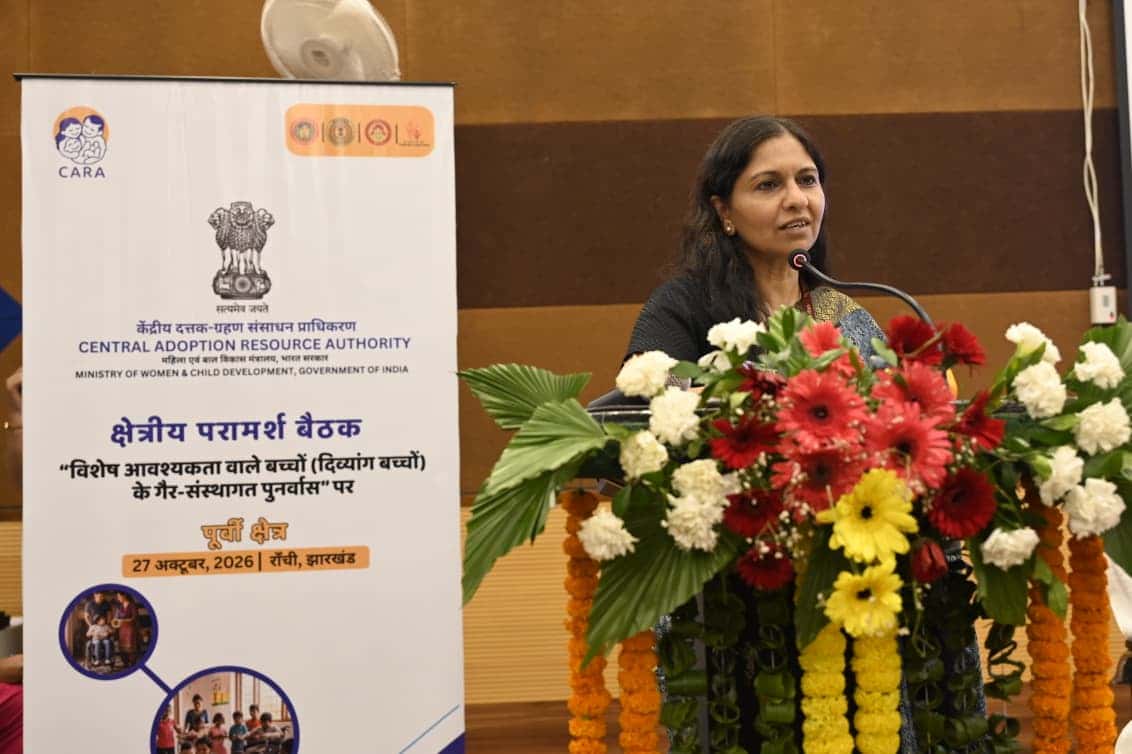 फूलों से सजे पोडियम पर माइक के सामने बोलती एक महिला। बाईं ओर CARA के लोगो वाला बैनर लगा है, जिस पर पूर्वी क्षेत्र की क्षेत्रीय परामर्श बैठक और 27 अक्टूबर 2026, रांची, झारखंड लिखा है।